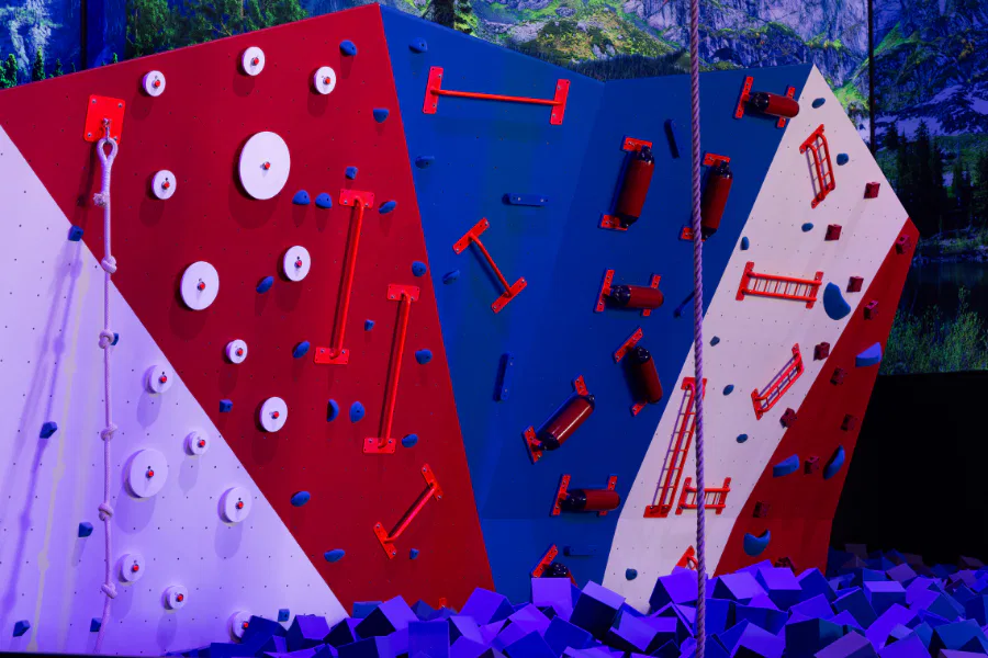 Climbing wall at The Rush Funplex featuring vibrant red, white, and blue colors.